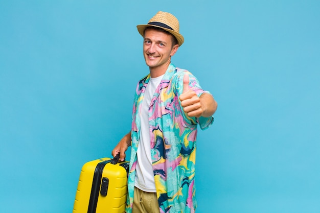 Hombre guapo joven que se siente orgulloso, despreocupado, seguro y feliz, sonriendo positivamente con los pulgares hacia arriba