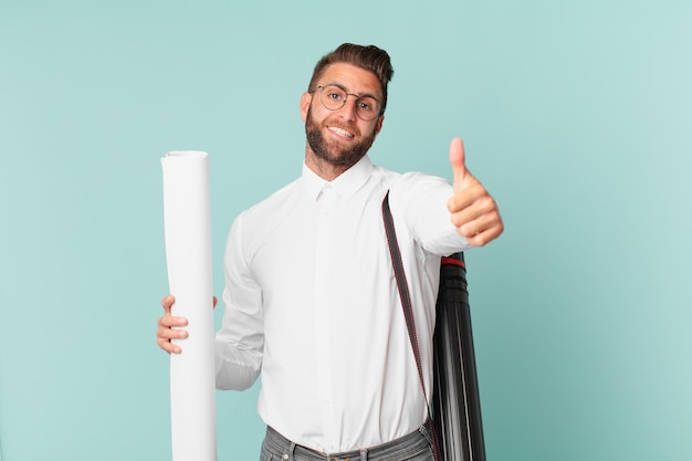 Hombre guapo joven que se siente orgulloso, sonriendo positivamente con los pulgares hacia arriba. concepto de arquitecto