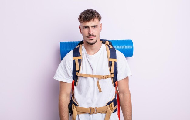 Hombre guapo joven que se siente triste, molesto o enojado y mirando hacia un lado. concepto de excursionista