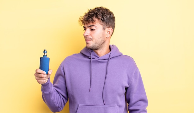 Hombre guapo joven que se siente triste, molesto o enojado y mirando hacia un lado. concepto de vaporizador