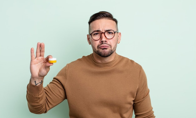 Foto hombre guapo joven que se siente triste y quejumbroso con una mirada infeliz y llorando. lentes de contacto