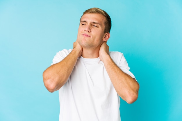 Hombre guapo joven que sufre dolor de cuello debido al estilo de vida sedentario