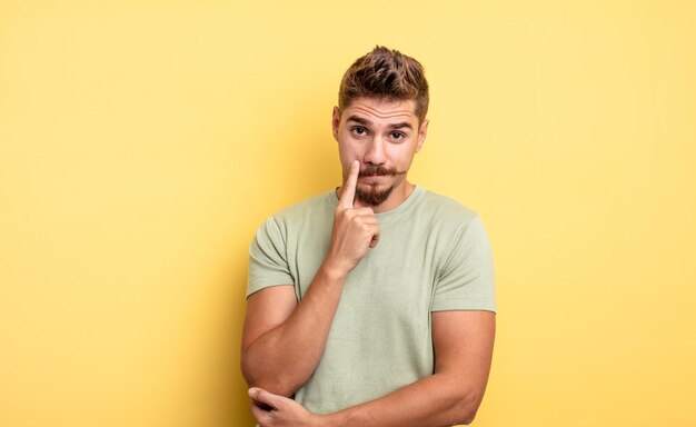 Hombre guapo joven que te vigila sin confiar en mirar y permanecer alerta y vigilante concepto de bigote extraño