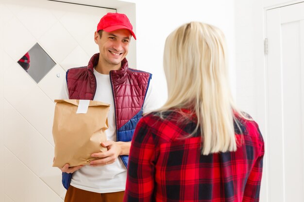 Hombre guapo joven repartiendo comida en un apartamento