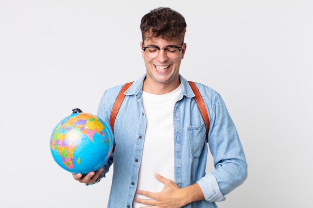 Hombre guapo joven riendo a carcajadas de una broma hilarante. estudiante sosteniendo un mapa del globo terráqueo