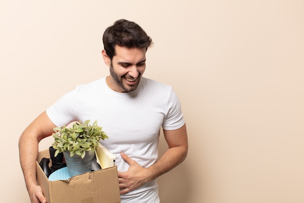 Hombre guapo joven riendo a carcajadas de una broma hilarante, sintiéndose feliz y alegre, divirtiéndose