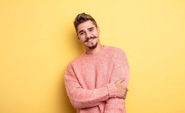 Hombre guapo joven riendo tímidamente y alegremente, con una actitud amistosa y positiva pero insegura. extraño concepto de bigote