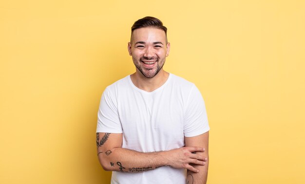 Hombre guapo joven riendo tímidamente y alegremente, con una actitud amistosa y positiva pero insegura