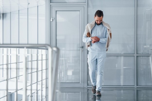 Hombre guapo joven en ropa formal en el interior de la oficina durante el día