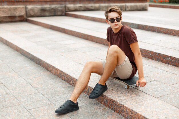 Hombre guapo joven sentado en una patineta