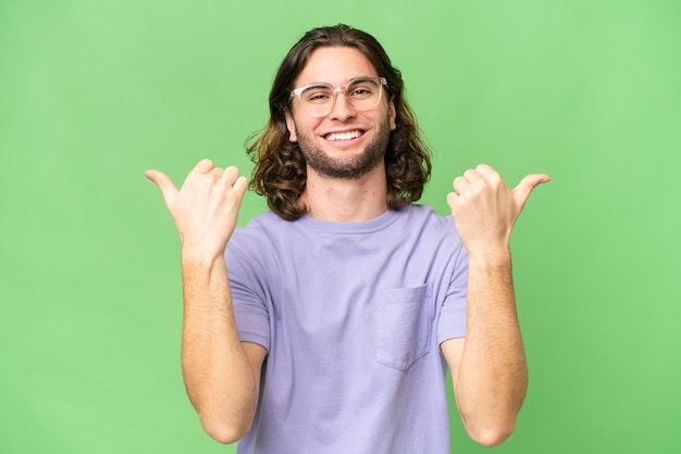 Hombre guapo joven sobre fondo aislado con gesto de pulgares arriba y sonriendo