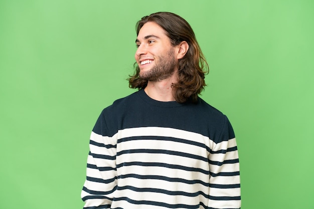 Hombre guapo joven sobre fondo aislado mirando hacia el lado