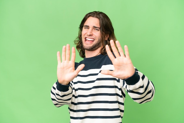 Hombre guapo joven sobre fondo aislado nervioso estirando las manos al frente