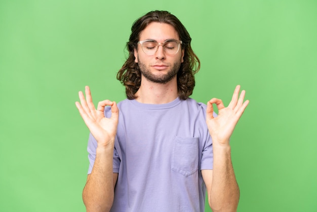 Hombre guapo joven sobre fondo aislado en pose zen