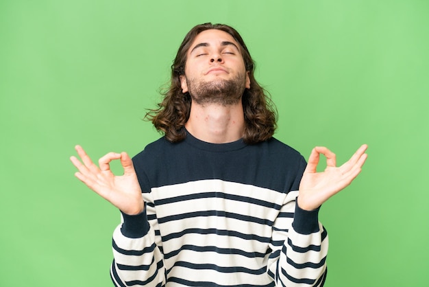 Foto hombre guapo joven sobre fondo aislado en pose zen