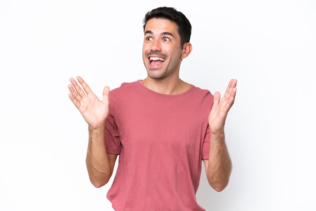 Hombre guapo joven sobre fondo blanco aislado con expresión facial sorpresa