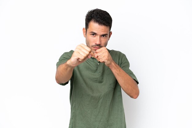 Hombre guapo joven sobre fondo blanco aislado con gesto de lucha