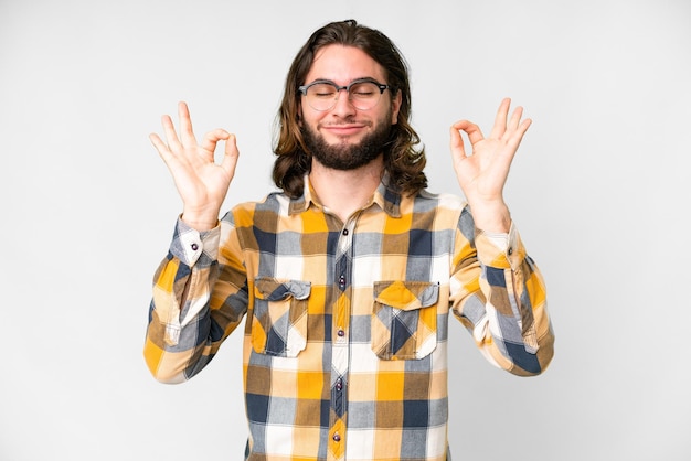 Hombre guapo joven sobre fondo blanco aislado en pose zen