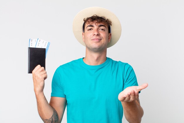 Hombre guapo joven sonriendo felizmente con amable y ofreciendo y mostrando un concepto. viajero sosteniendo su pasaporte