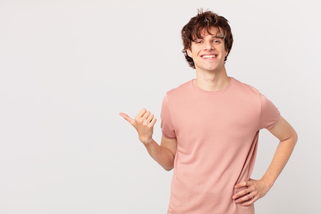 Hombre guapo joven sonriendo felizmente con una mano en la cadera y confiado