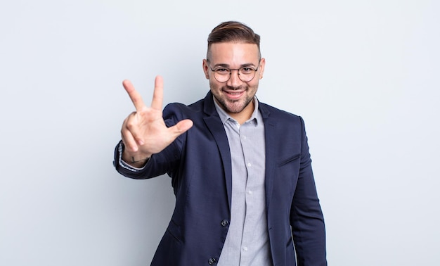 Foto hombre guapo joven sonriendo y luciendo amigable, mostrando el número tres. concepto de empresario