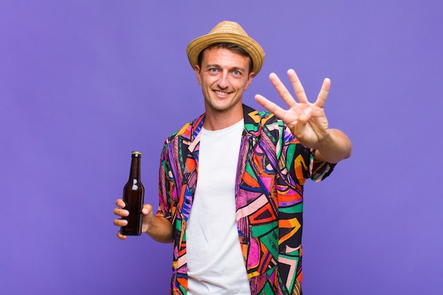 Hombre guapo joven sonriendo y mirando amigablemente, mostrando el número cuatro o cuarto con la mano hacia adelante, contando hacia atrás