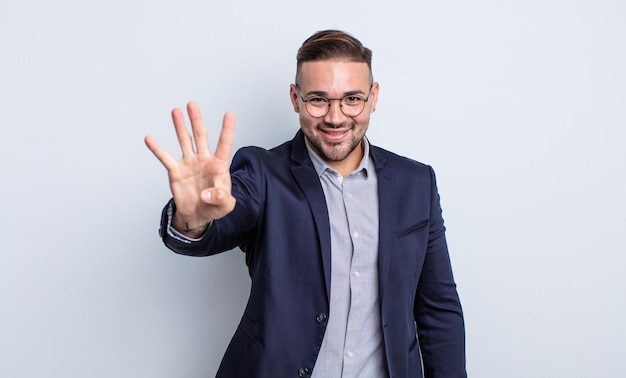 Hombre guapo joven sonriendo y mirando amistoso, mostrando el número cuatro. concepto de empresario