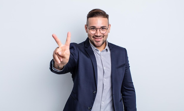 Hombre guapo joven sonriendo y mirando amistoso, mostrando el número dos. concepto de empresario