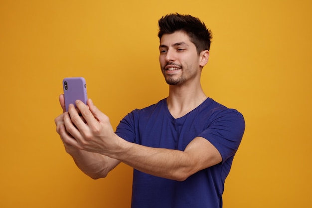 Hombre guapo joven sonriente tomando selfie sobre fondo amarillo