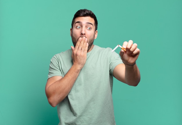 Hombre guapo joven sosteniendo un cigarrillo. dejar de fumar concepto