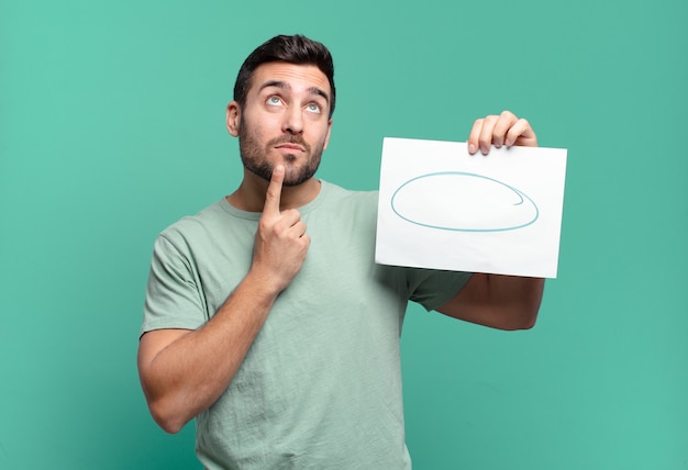 Hombre guapo joven sosteniendo una hoja de papel con un espacio de copia