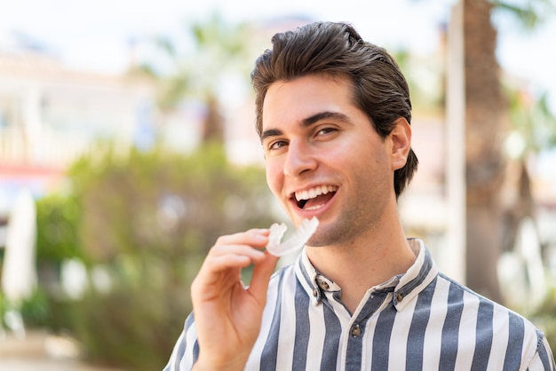 Hombre guapo joven sosteniendo llaves invisibles