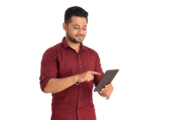 Hombre guapo joven sosteniendo y usando un teléfono inteligente o un teléfono móvil o una tableta en un fondo blanco