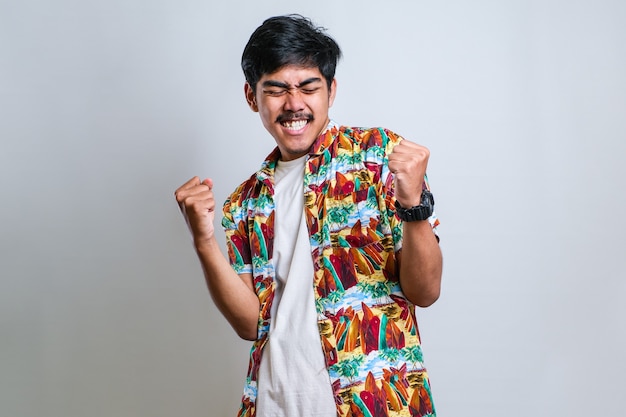 Hombre guapo joven con suéter casual de pie sobre fondo blanco aislado muy feliz y emocionado haciendo gesto de ganador con los brazos levantados, sonriendo y gritando por el éxito. Concepto de celebración