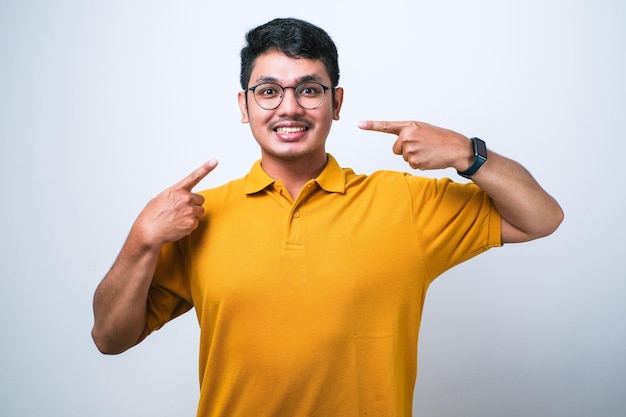 Hombre guapo joven con suéter casual de pie sobre fondo blanco aislado sonriendo alegre mostrando y señalando con los dedos los dientes y la boca Concepto de salud dental