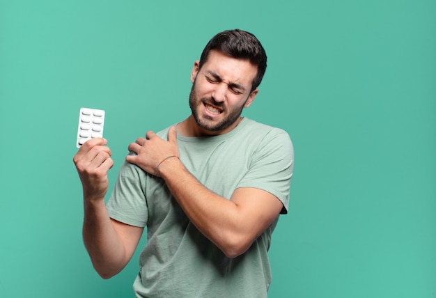 Hombre guapo joven con una tableta de pastillas