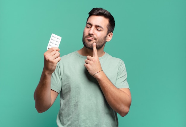 Hombre guapo joven con tableta de pastillas