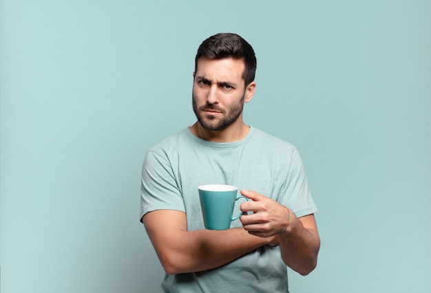 Hombre guapo joven con una taza de café. concepto de desayuno