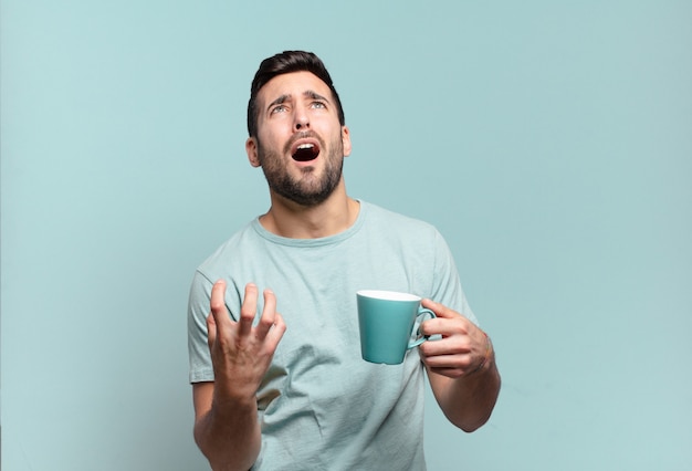 Hombre guapo joven con una taza de café