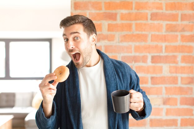 Hombre guapo joven tomando un café en casa