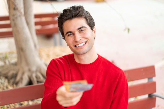 Foto hombre guapo joven tomando mucho dinero