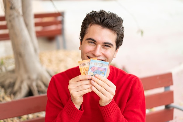 Hombre guapo joven tomando mucho dinero