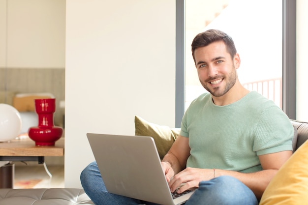 Hombre guapo joven usando una computadora portátil