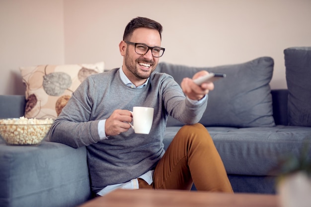 Hombre guapo joven viendo la televisión en casa