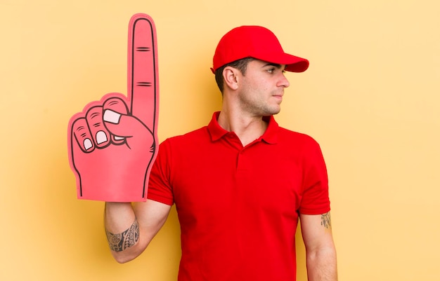 Foto hombre guapo joven en vista de perfil pensando imaginando o soñando despierto el concepto de mano número uno