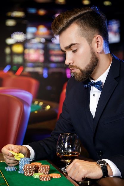 Hombre guapo jugando a la ruleta en el casino