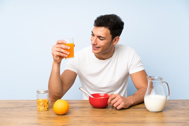 Hombre guapo con un jugo de naranja