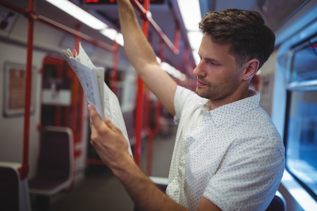 Hombre guapo leyendo periódico