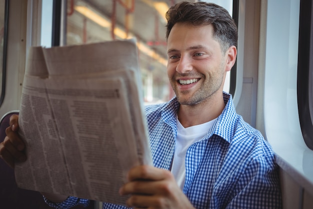 Hombre guapo leyendo periódico