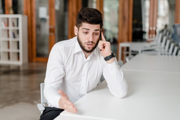 Hombre guapo en el lugar de trabajo con teléfono